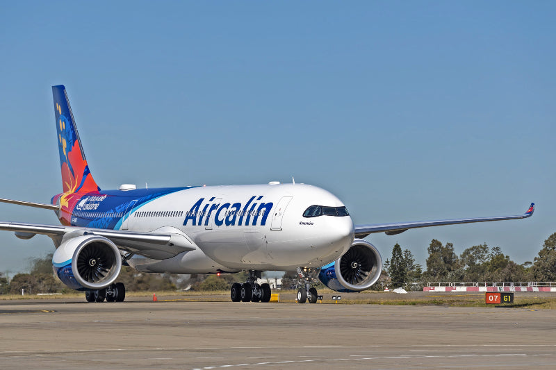 Aircalin airplane on a runway with a clear blue sky